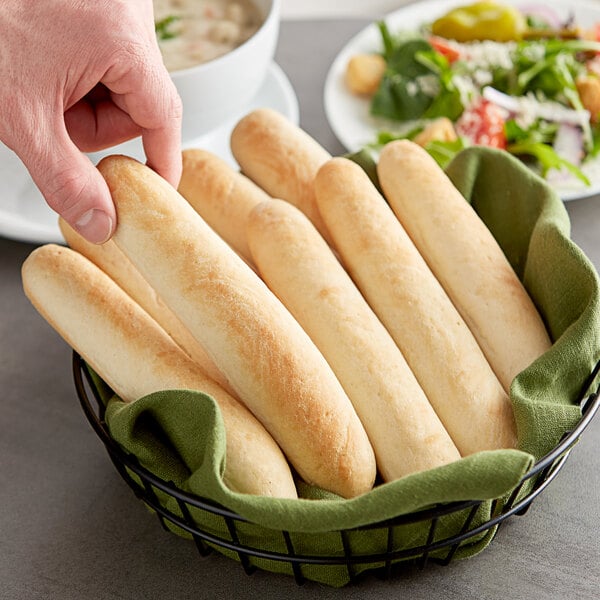A basket of Turano gourmet bread sticks on a table in a hotel buffet.