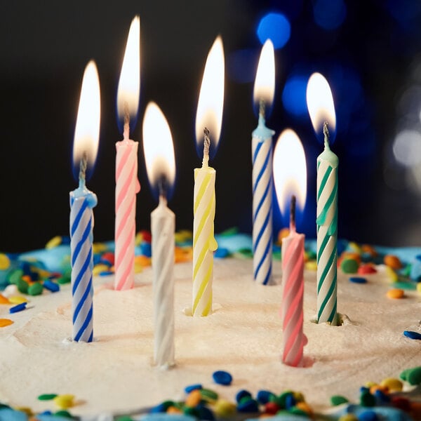 A close-up of Sterno multi-colored birthday candles on a cake.