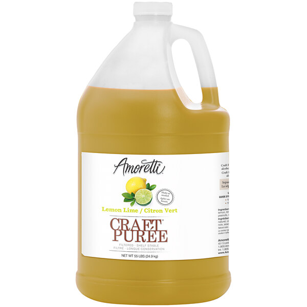 A jug of Amoretti Lemon-Lime Craft Puree with a lemon and lime.