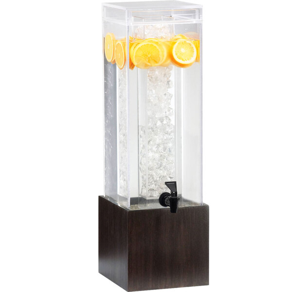 A Cal-Mil bamboo beverage dispenser filled with water, lemons, and ice.