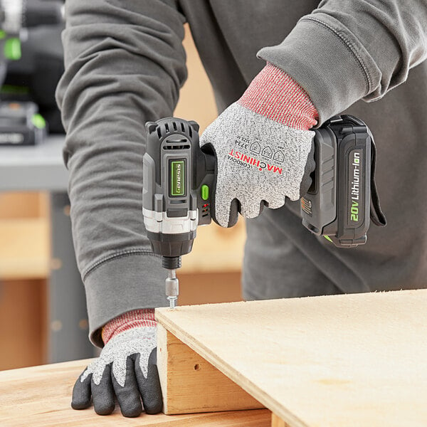A person using the Genesis cordless drill to drill a wooden box.