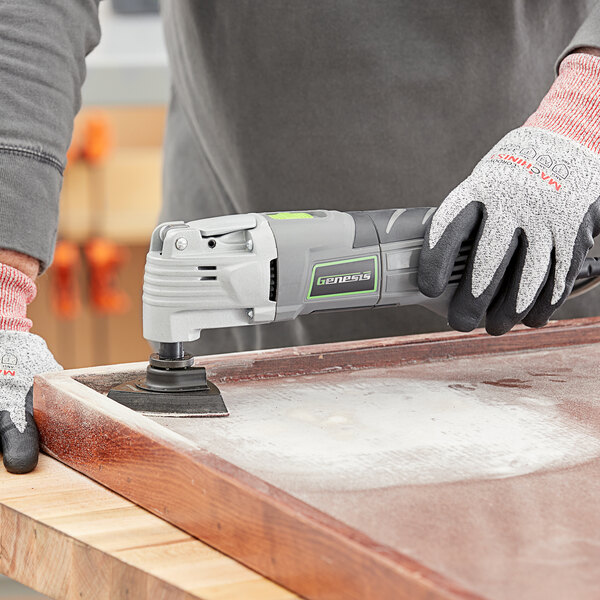 A person using a Genesis power tool to polish a piece of wood.