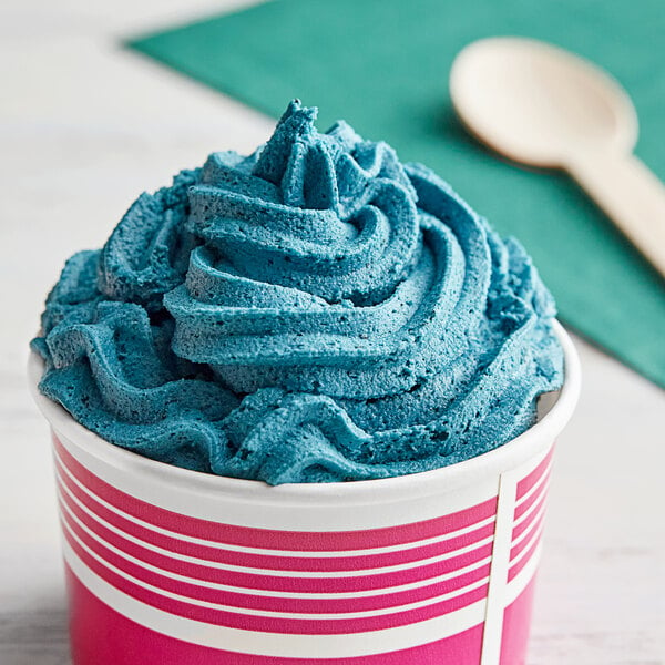 A cup of blue Gelato Lab Cookie Monster soft serve with a spoon.