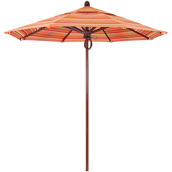 A California Umbrella with an orange striped canopy on a wooden pole.