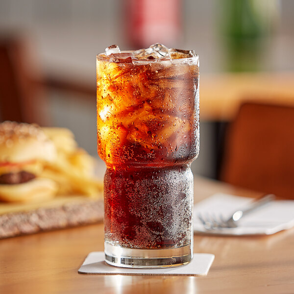 A Mug&amp;#174; soda with ice and a burger on a table.