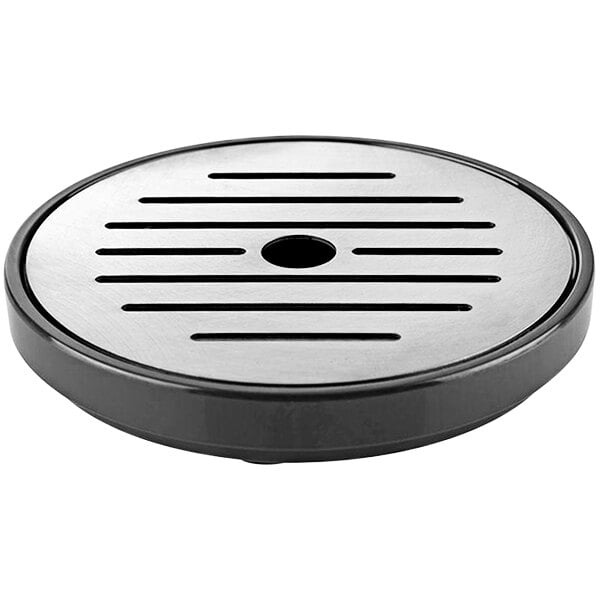 A black round stainless steel drip tray with lines on it and a hole in the center.