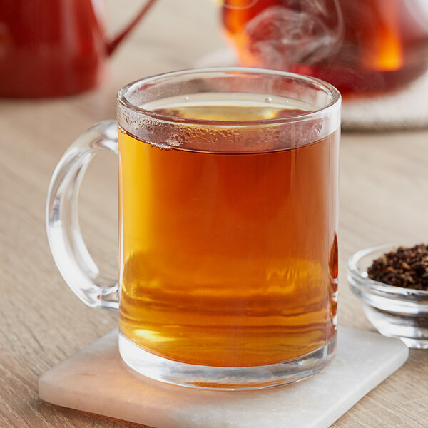 A glass mug of brown Davidson's Organic Decaf Cinnamon Apple tea.
