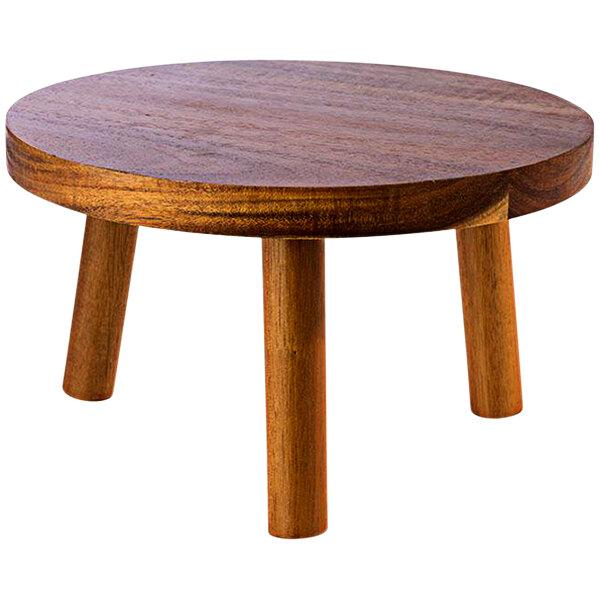 A round wooden buffet stand with three legs.