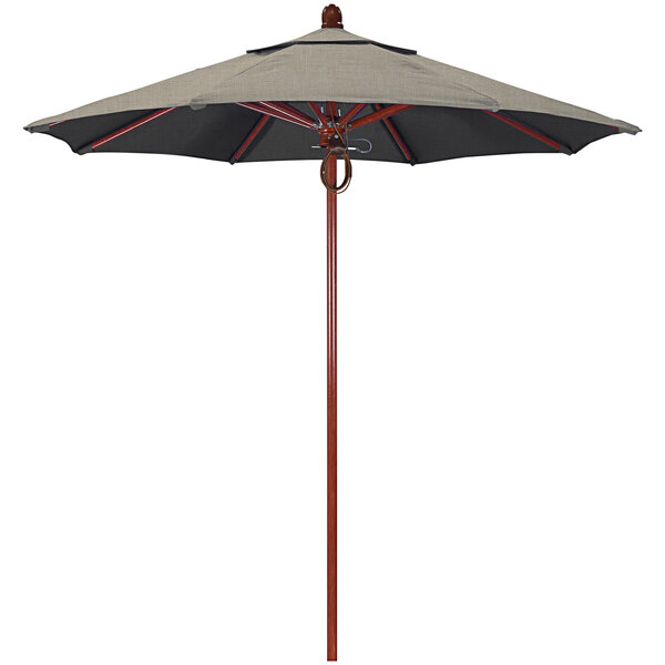 A close-up of a California Umbrella with a tan canopy and a wooden pole.