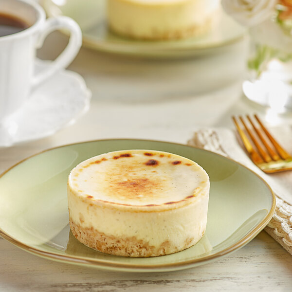 A round white Sweet Street Desserts gluten-free vanilla bean brulee cheesecake with a burnt crust on a plate.
