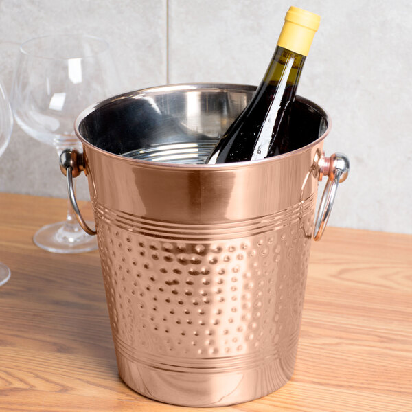 An American Metalcraft hammered copper wine bucket with a bottle of wine in it.
