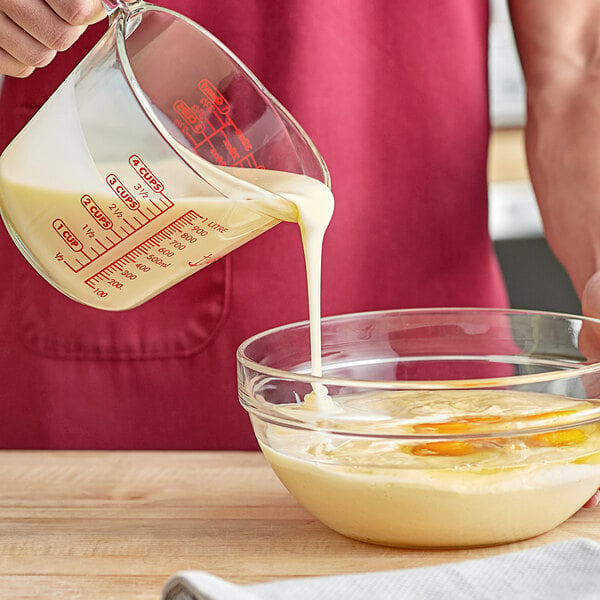 A person pouring California Farms sweetened condensed milk into a bowl of food.