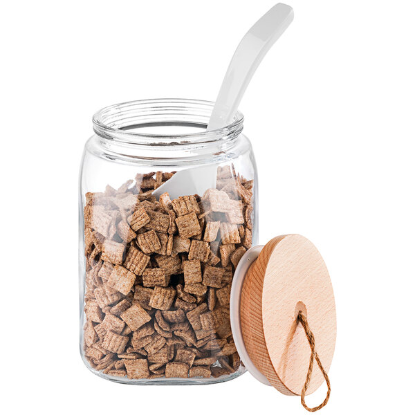 An APS Woody square glass jar with cereal inside and a spoon in it.