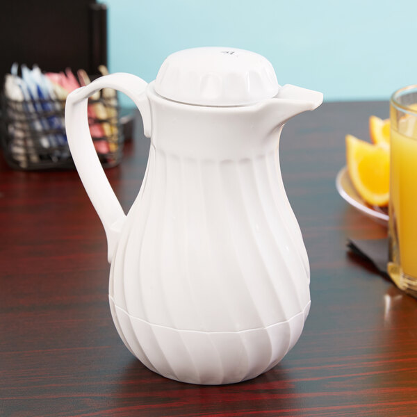 A white Vollrath SwirlServe beverage server on a table.