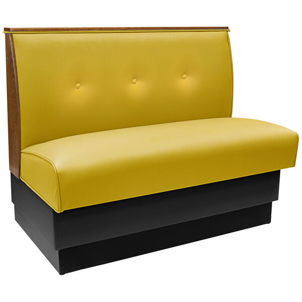An American Tables & Seating yellow upholstered booth with a tufted back and black end caps.