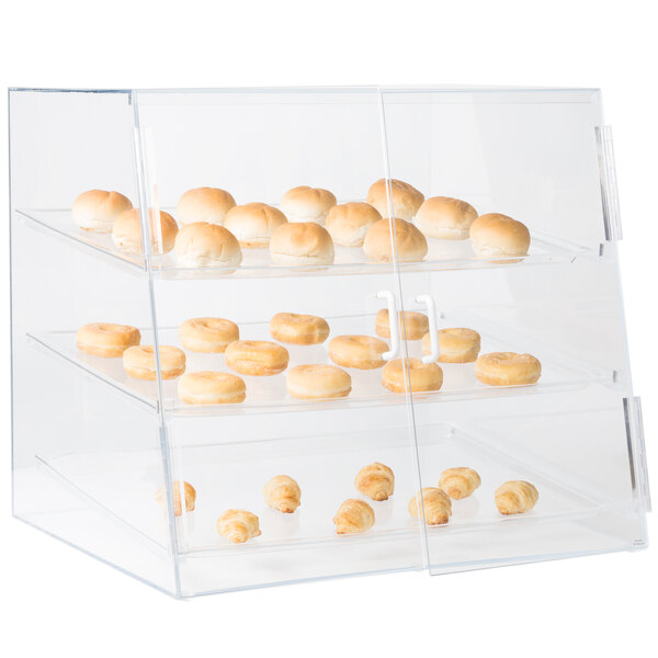 A clear Cal-Mil display case with many donuts.