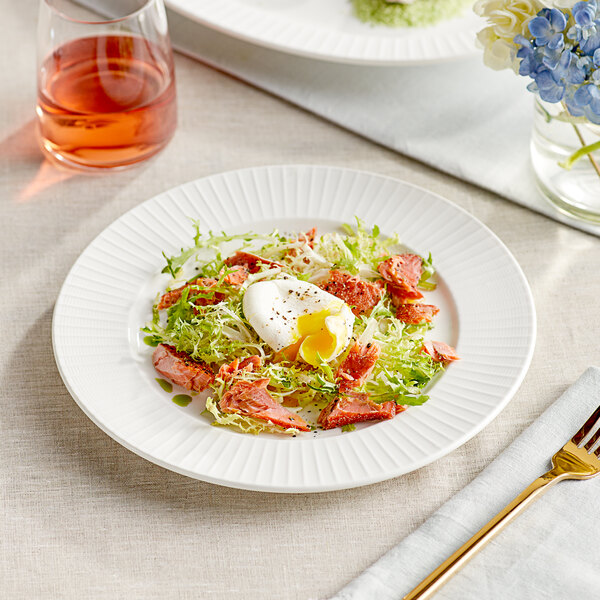 A plate of salad with a fork on a white Acopa Cordelia porcelain plate.