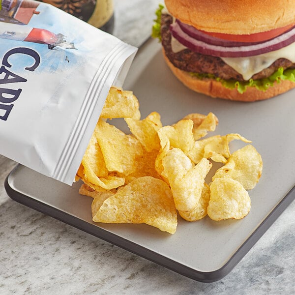 A plate with a burger and a bag of Cape Cod Original Sea Salt Kettle Cooked Potato Chips.