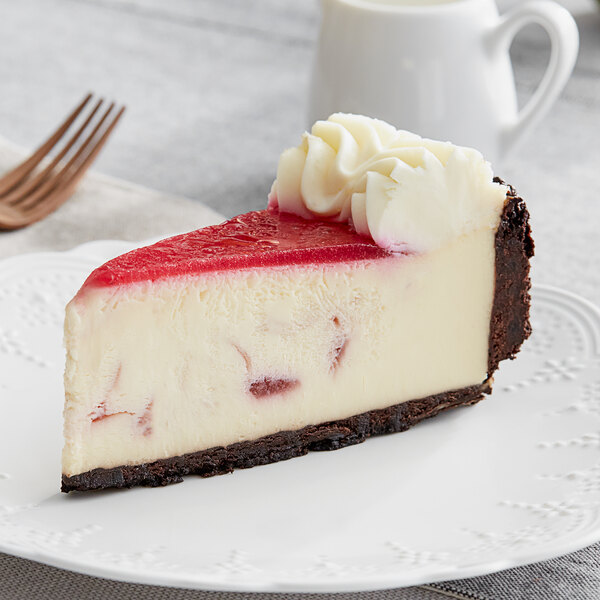 A slice of Eli's White Chocolate Raspberry Cheesecake with red and white swirls on a plate.