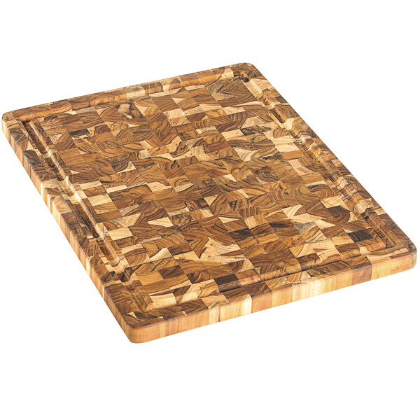 A Teakhaus end grain cutting board with a wooden pattern and hand grips.