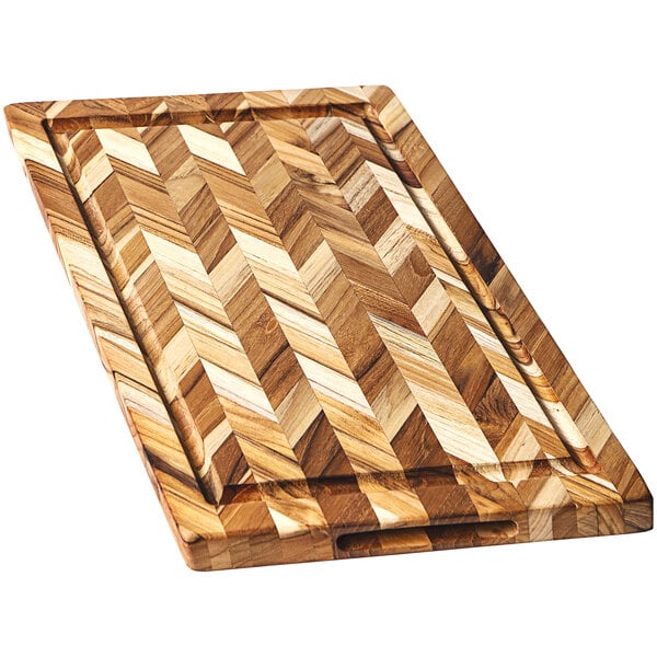 A Teakhaus edge grain teakwood cutting board with a herringbone pattern and hand grips.