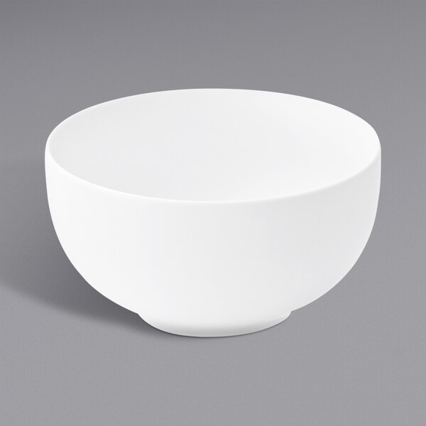 Oneida Verge warm white porcelain Jung bowl on a gray surface.