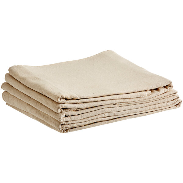 A stack of folded beige canvas drop cloths.