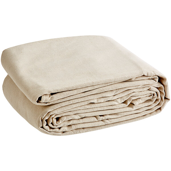 A stack of folded beige Monarch Brands canvas drop cloths on a white background.