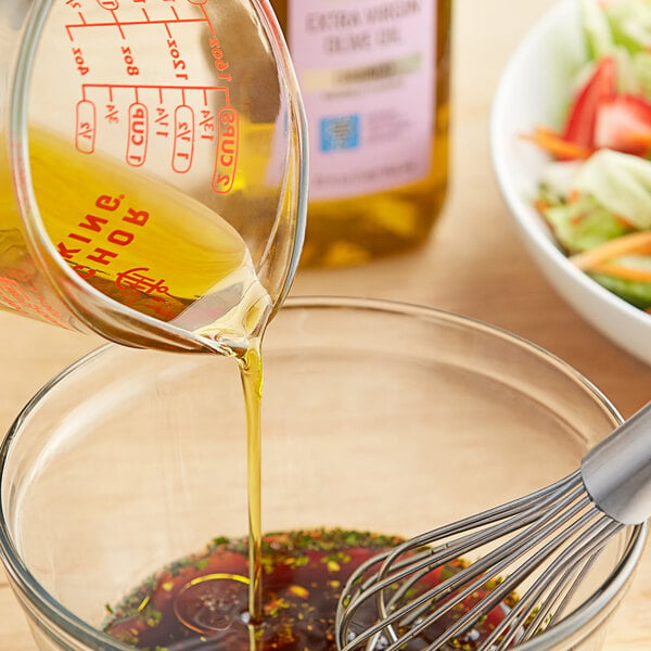 A bowl of salad with Colavita Roasted Garlic Extra Virgin Olive Oil dressing.