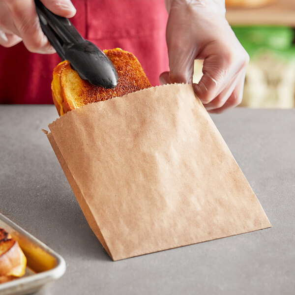 A person putting toast in a Choice dry waxed kraft sandwich bag.