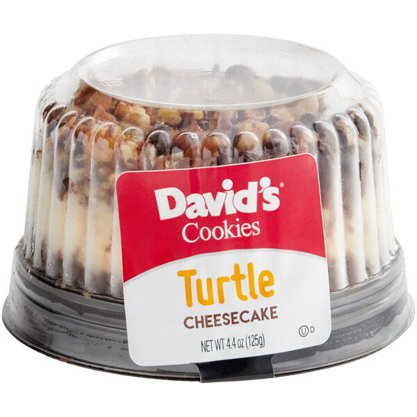 A David's Cookies turtle cheesecake on a table in a bakery display.