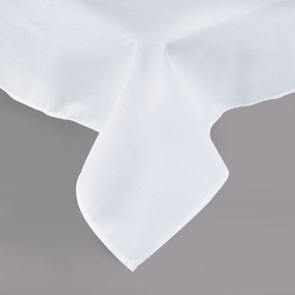 A close-up of a white rectangular tablecloth with a folded hem.