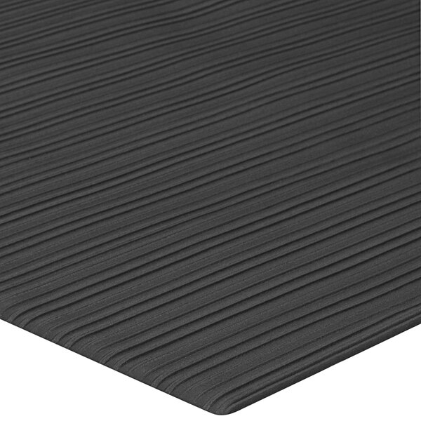 A close up of a black Lavex anti-fatigue mat with a ribbed stripe pattern.