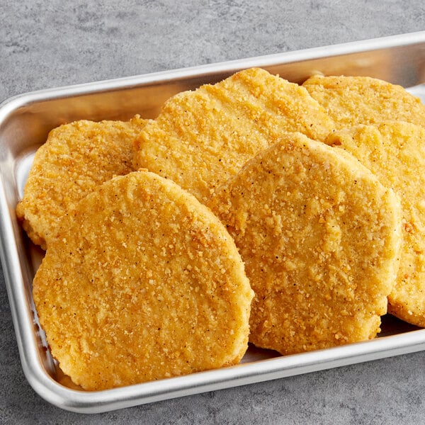 A tray of Rebellyous Vegan Plant-Based Chicken Patties on a gray surface.