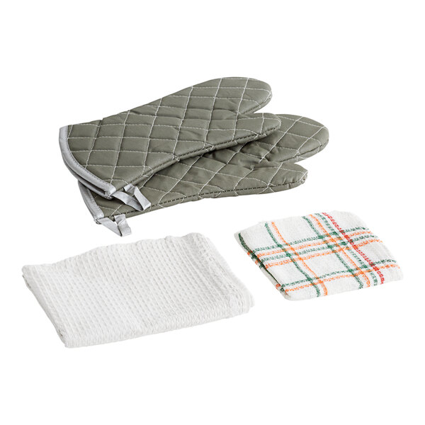 A pair of white flame retardant oven mitts and a green waffle-weave towel.