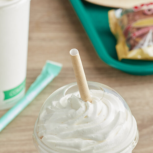 A close up of a SOFi giant wrapped kraft paper straw in a white cup of yogurt.
