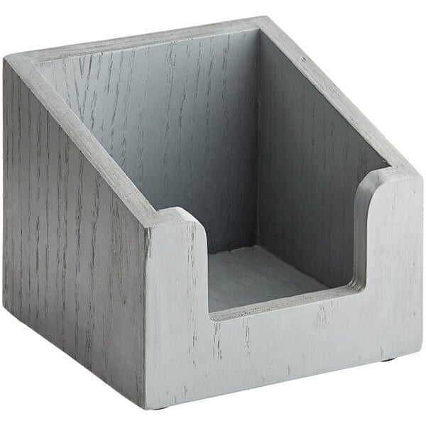 A gray wooden Cal-Mil napkin holder with a hole on top of a table.