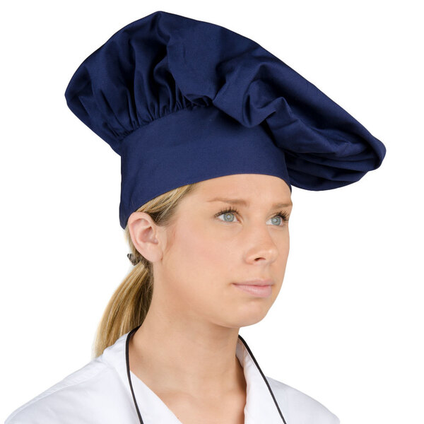 A woman wearing a navy blue Intedge chef hat.