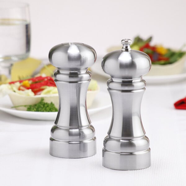 A silver salt shaker and pepper mill set on a table.