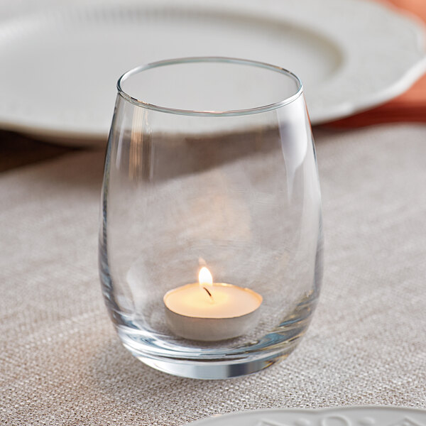 An Acopa bubble glass candle holder with a lit candle inside.
