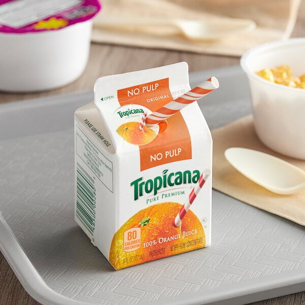 A tray with a carton of Tropicana Pure Premium Orange Juice next to a cup of food.