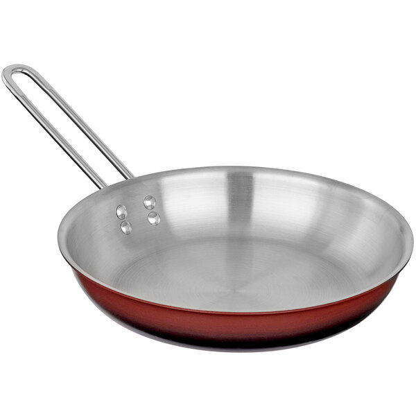 A stainless steel frying pan with red ombre coloring on the outside.