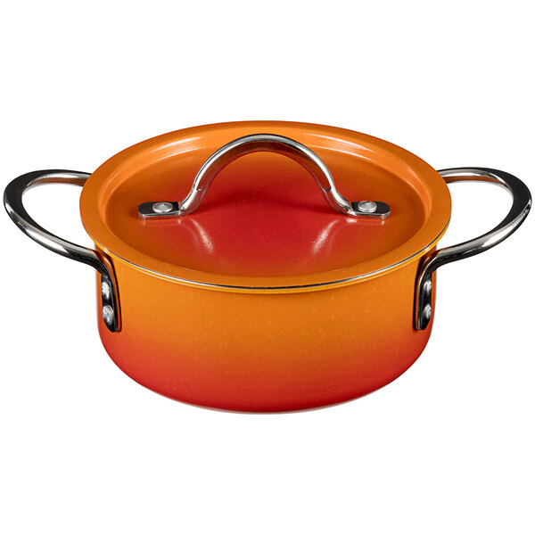 A Bon Chef Country French Ombre Tangerine sauce pot with a handle and cover.