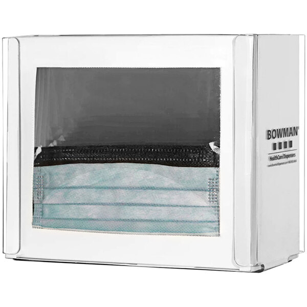 A clear plastic tabletop and wall mountable dispenser with a white box of face masks inside.