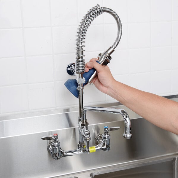 A person using a T&S Mini Pre-Rinse Faucet to wash their hands.