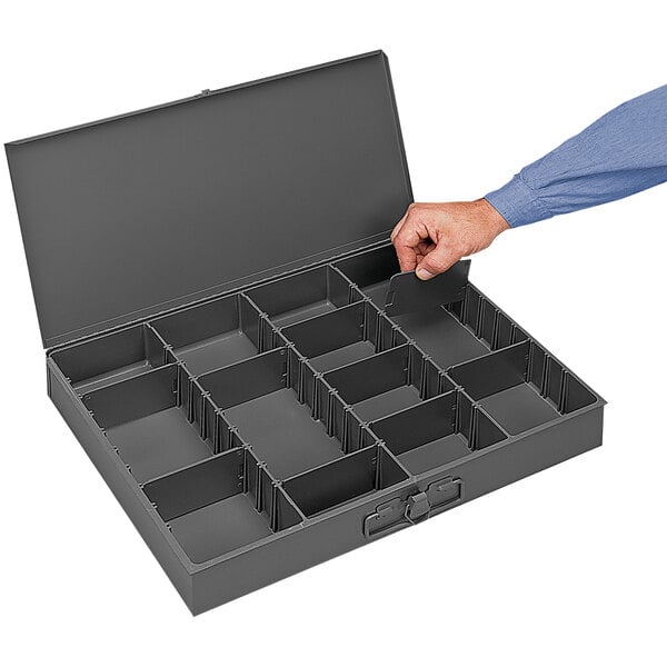 A hand holding a Durham Mfg steel box with small compartments.