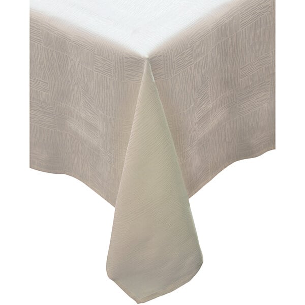 A close-up of a white Garnier-Thiebaut cloth table cover with a white pattern on the border.