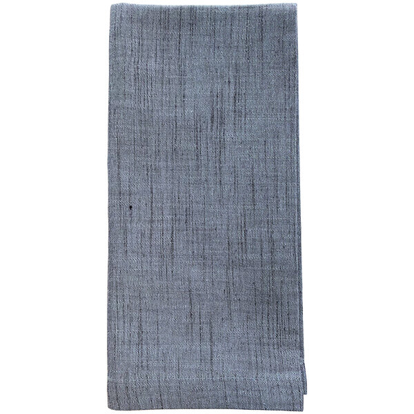 A close up of a Garnier-Thiebaut Denim Blue cloth napkin with a small design.