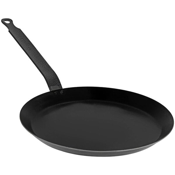 A black de Buyer carbon steel crepe pan with a handle.