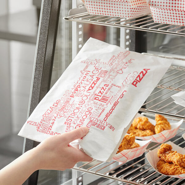 A hand holding a Choice printed paper bag of fried chicken.